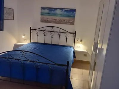 a bedroom with a bed with a blue comforter at Casa Cinque Torri in San Vito lo Capo
