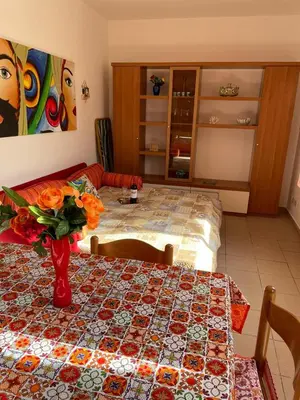 a room with a table with a vase of flowers on it at Casa Cinque Torri in San Vito lo Capo