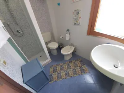 a small bathroom with a toilet and a sink at Casa Cinque Torri in San Vito lo Capo