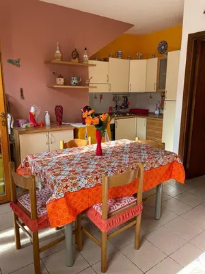 a kitchen with a table with a vase of flowers on it at Casa Cinque Torri in San Vito lo Capo