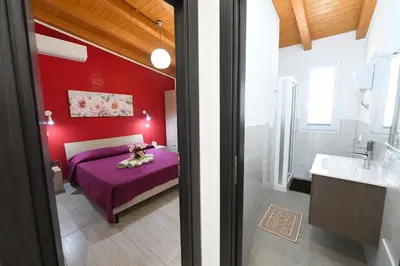 a red bedroom with a bed and a sink at AL Quadrifoglio in Terrasini