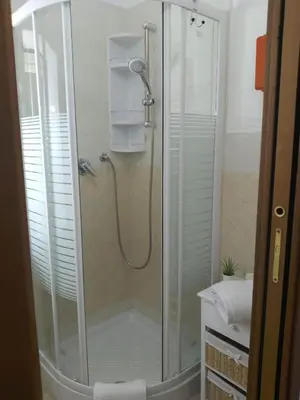 a shower with a glass door in a bathroom at Mo MA in Palermo