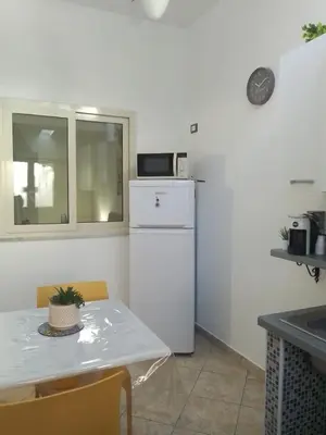 a kitchen with a table and a white refrigerator at Mo MA in Palermo