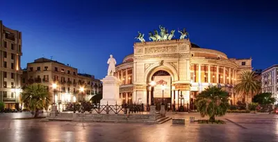 a large building with a statue in front of it at Mo MA in Palermo