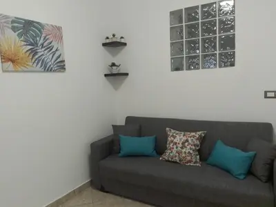 a couch in a living room with two pictures on the wall at Mo MA in Palermo