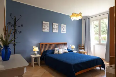 a blue bedroom with a bed and a blue wall at VillaThomas in Campofelice di Roccella