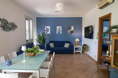 a living room with a blue couch and a table at VillaThomas in Campofelice di Roccella