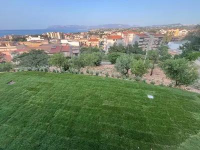 a green field with a city in the background at Tenuta Rapillo in Castellammare del Golfo