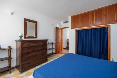 a bedroom with a blue bed and a wooden dresser at La Veranda Sul Mare in Santa Flavia