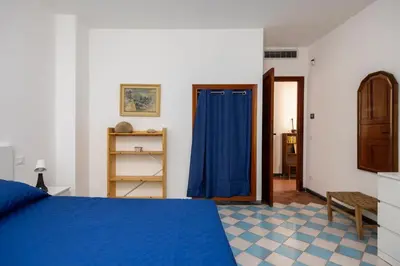 a bedroom with a blue bed and a blue curtain at La Veranda Sul Mare in Santa Flavia