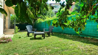 two chairs and a bench in a yard at Villa Triscele Holiday Home in Partinico