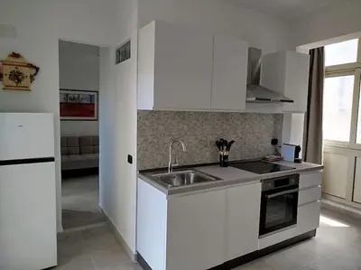 a white kitchen with a sink and a refrigerator at 7 floor in Palermo