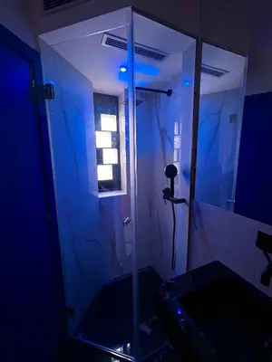 a bathroom with a glass shower with a blue light at Zagara in Palermo