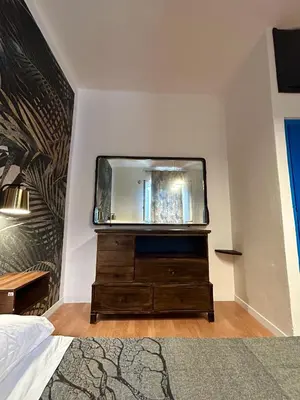 a bedroom with a dresser with a tv on the wall at Zagara in Palermo