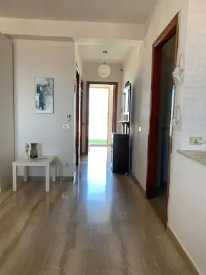 an empty room with a hallway with a hard wood floor at Attico con vista mozzafiato a due passi dal mare in Terrasini