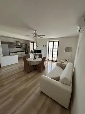 a living room with a white couch and a table at Attico con vista mozzafiato a due passi dal mare in Terrasini