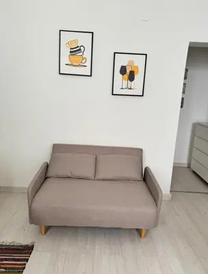 a couch in a living room with two pictures on the wall at Ballar'Home - Casa Sbriju' in Palermo