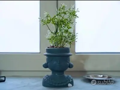 a plant in a blue vase sitting on a table at Ballar'Home - Casa Sbriju' in Palermo