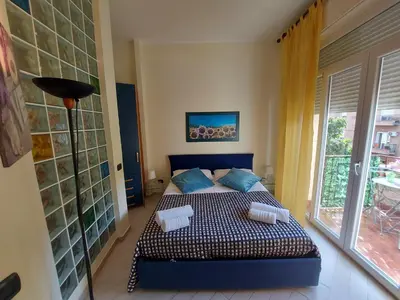 a bedroom with a bed with blue pillows and a window at Teatro Massimo - Apartment with Private Balcony in Palermo