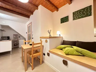 a room with a bed and a table and a kitchen at Marcantonio Suite in Castellammare del Golfo