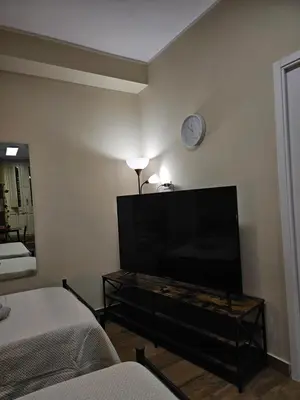 a living room with a tv and a clock on the wall at RC SUITE Annunziata in Termini Imerese