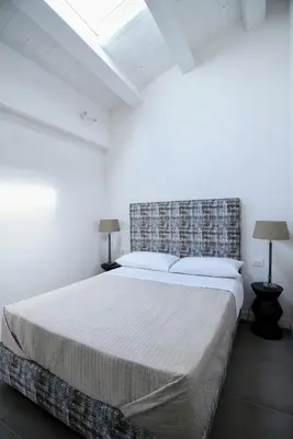 a bedroom with a large bed in a white room at Maciuni Apartment in Palermo
