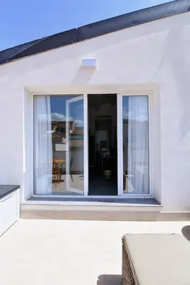 a sliding glass door on a white house at Maciuni Apartment in Palermo