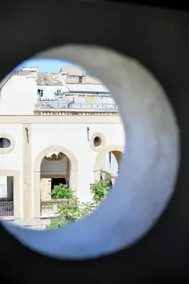 a view of a building through a hole in a building at Maciuni Apartment in Palermo