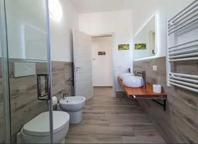 a bathroom with two sinks and a toilet and a mirror at Villa Charme & Relax in Campofelice di Roccella
