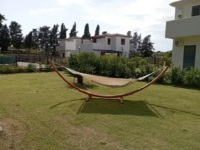 a hammock sitting in the middle of a yard at Villa Charme & Relax in Campofelice di Roccella