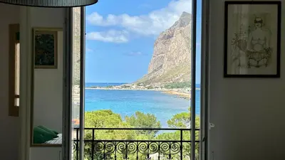 a room with a view of the ocean from a balcony at La Terrazza sul Mare in Palermo
