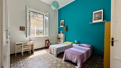a room with two beds and a blue wall at La Terrazza sul Mare in Palermo