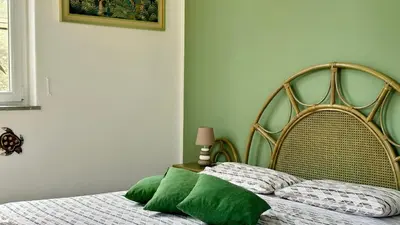 a bed with green pillows on it in a bedroom at La Terrazza sul Mare in Palermo