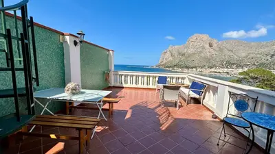 a balcony with a table and chairs and the ocean at La Terrazza sul Mare in Palermo