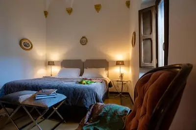 a bedroom with a bed and a table and a chair at Abbazia Santa Maria del Bosco in Contessa Entellina