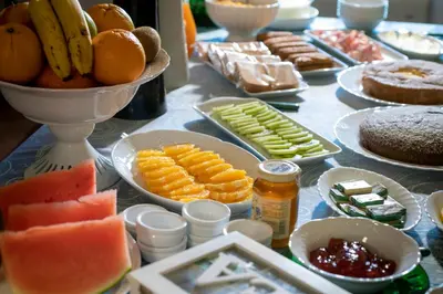 a table topped with plates of fruit and other foods at Abbazia Santa Maria del Bosco in Contessa Entellina
