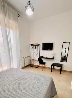a bedroom with a bed and a desk and a tv at Il Moro di Ballarò - Palermo Rooms in Palermo