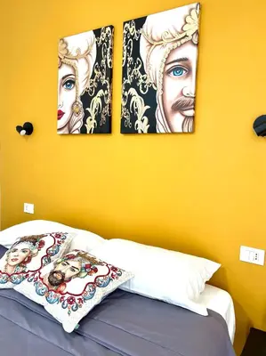 three pictures on the wall above a bed in a room at Il Moro di Ballarò - Palermo Rooms in Palermo