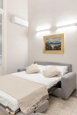 a bedroom with a bed and a picture on the wall at Zahir Suite Apartment in Palermo