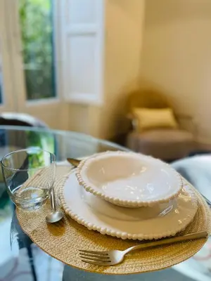 a plate on a glass table with a fork and knife at Zahir Suite Apartment in Palermo