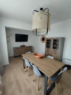 a dining room with a wooden table and chairs at V&J appartamenti in Carini
