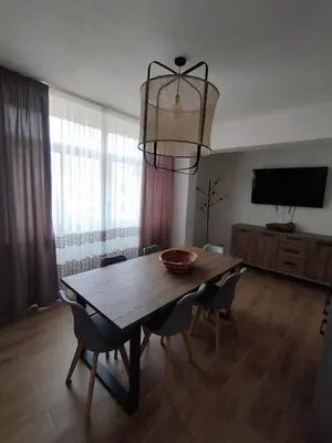 a dining room with a table and chairs and a television at V&J appartamenti in Carini