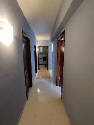 a hallway with blue walls and two doors and a carpet at V&J appartamenti in Carini