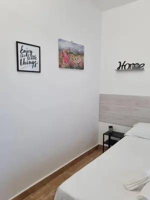 two beds in a room with two pictures on the wall at CITY HOUSE & FREE PARKING by Perry-Holiday moderno, panoramico e comodo fino a 6 ospiti in Palermo