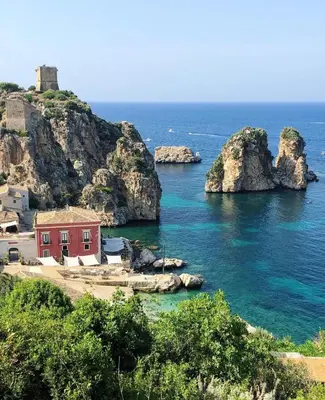 a red house in the middle of the ocean at Casa vinz in Scopello