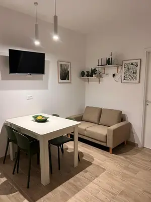 a living room with a table and a couch at Casa vinz in Scopello