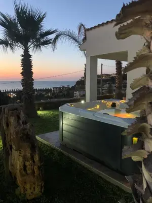 a hot tub in a yard with a palm tree at Villa Marina Luxury in Balestrate