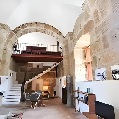 an archway in a building with a staircase and chairs at Antico frantoio in Palermo