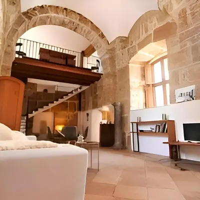 a living room with a bed and a staircase at Antico frantoio in Palermo
