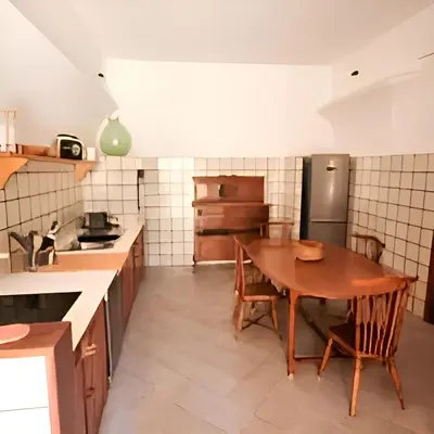 a kitchen with a wooden table and a refrigerator at Antico frantoio in Palermo